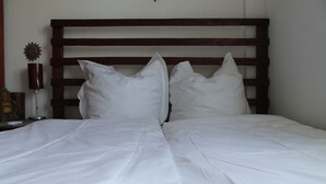 A neatly made bed with white linens and a wooden headboard. - Roger's Place Gay Guesthouse - Caters to Gay Men (Boracay Island)