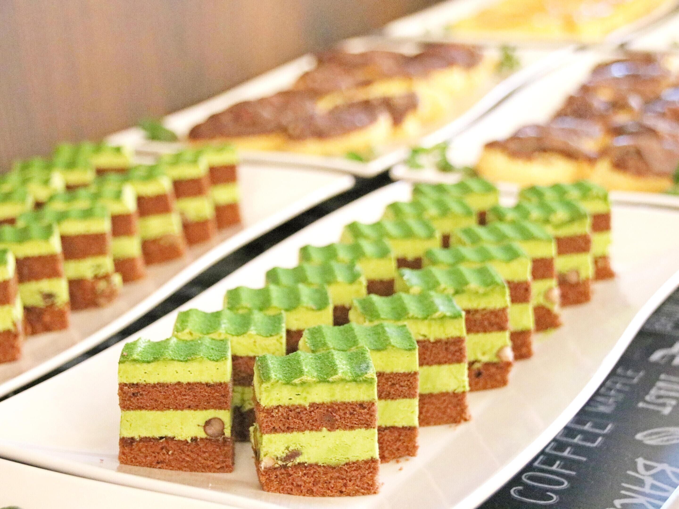 A tray of layered desserts with green and brown colors.