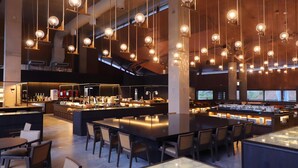 A spacious bar area with high ceilings, hanging spherical light fixtures, and a central bar counter with stools.