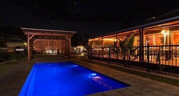 Una piscina al aire libre, sillones reclinables de piscina