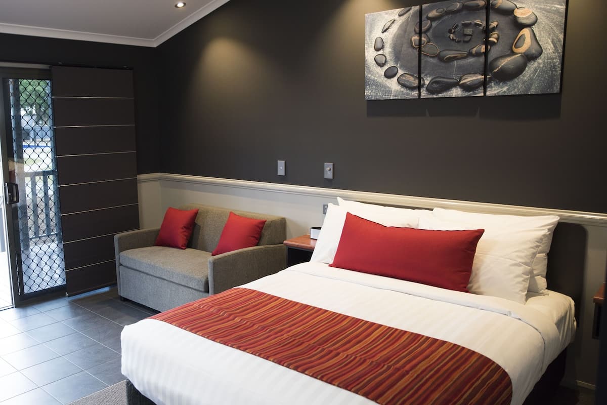 Une chambre d’hôtel moderne, dotée d’un grand lit, d’un canapé et d’une table à manger.