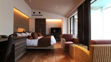 Quarto de hotel moderno com cama, escrivaninha, televisão e mobiliário de vime.