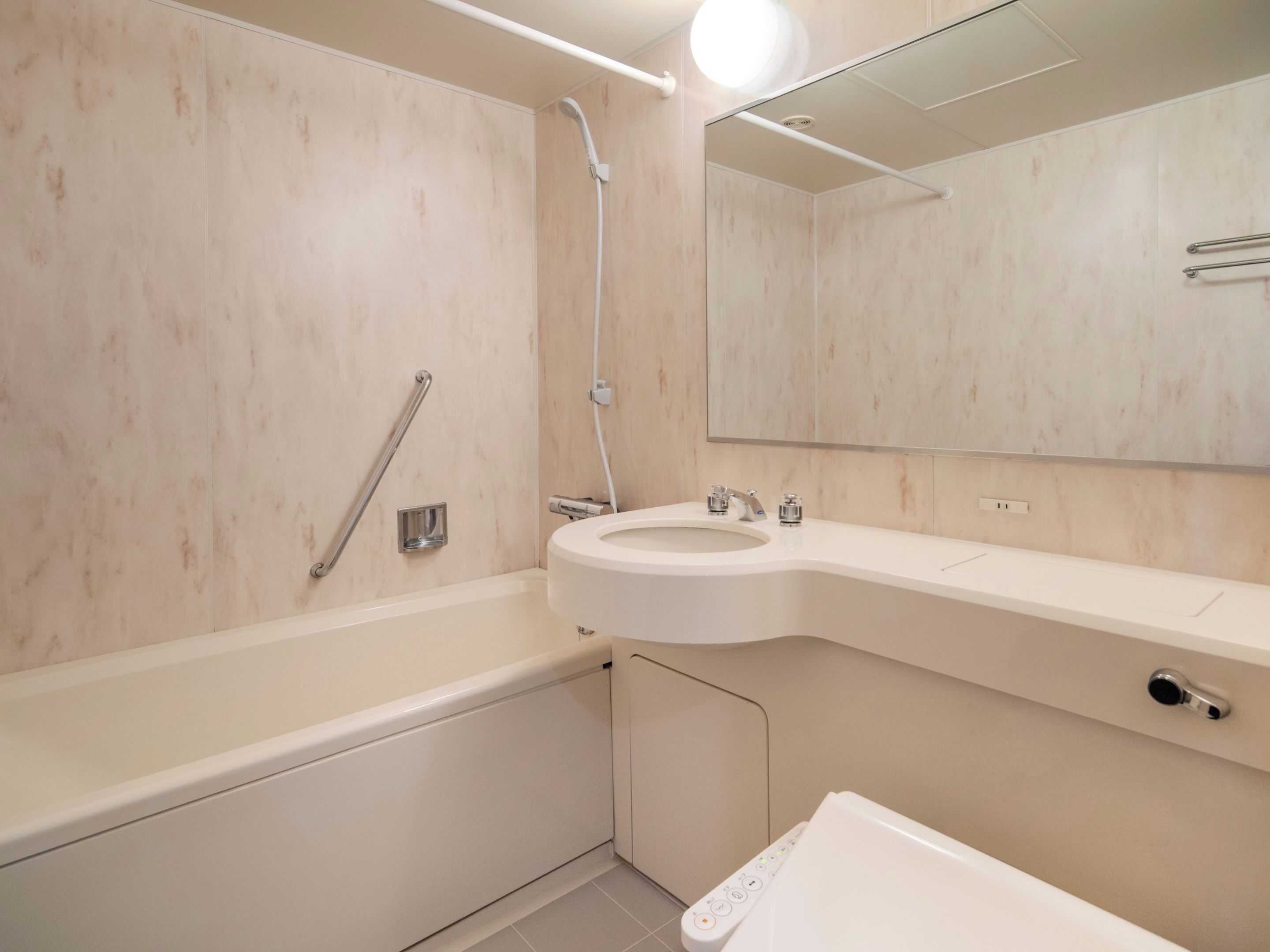 A modern bathroom with a bathtub, a sink, and a shower.