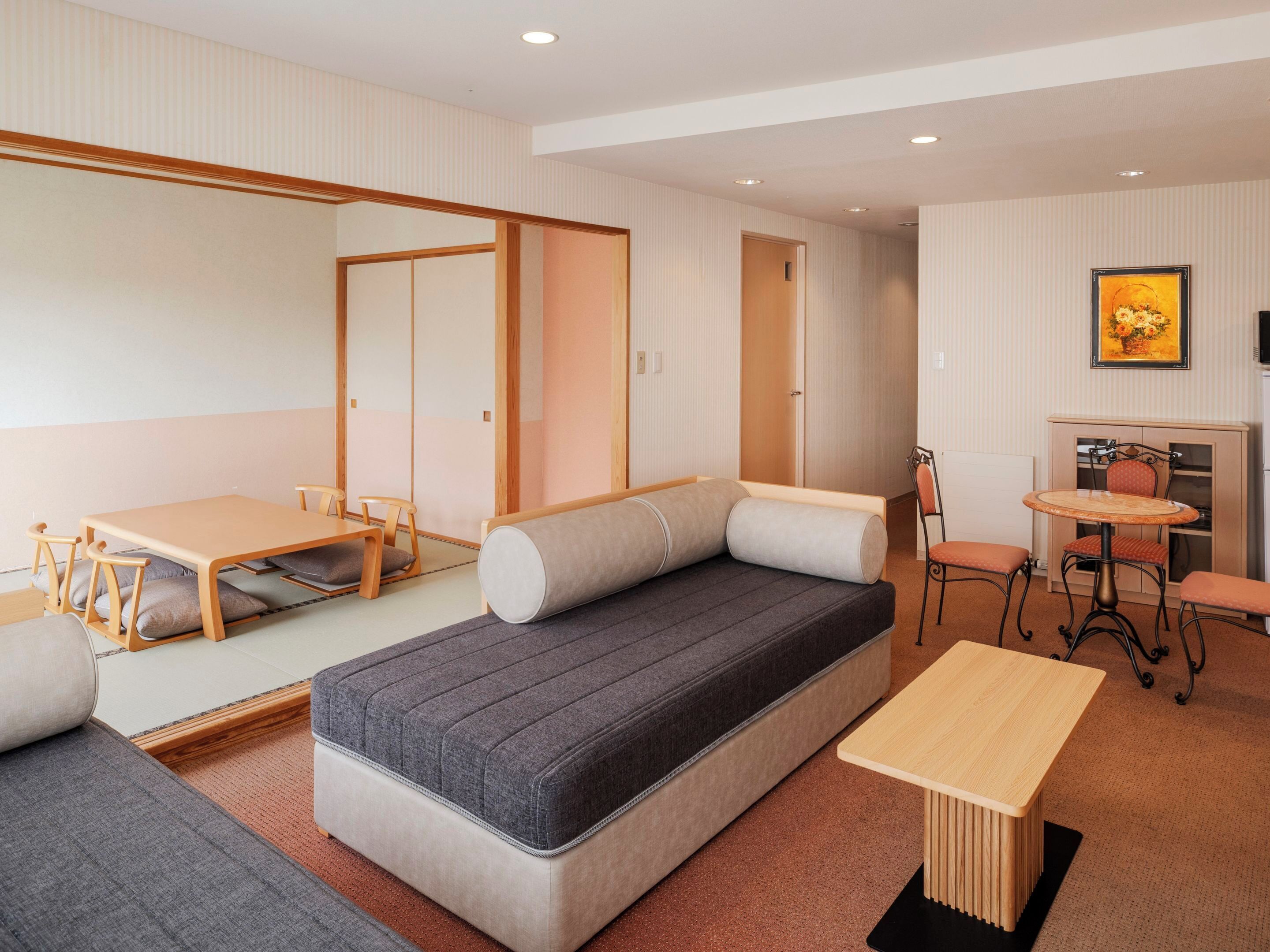 A compact room with a sofa, a small table, a chair, and a cabinet.