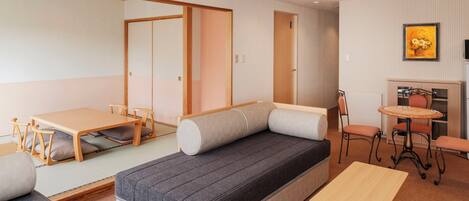 A compact room with a sofa, a small table, a chair, and a cabinet.
