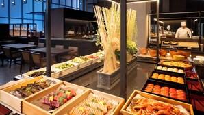 A buffet with various food items, a chef in the background, and a modern interior design. - AZUMINO KOGEN RESORT (Azumino)