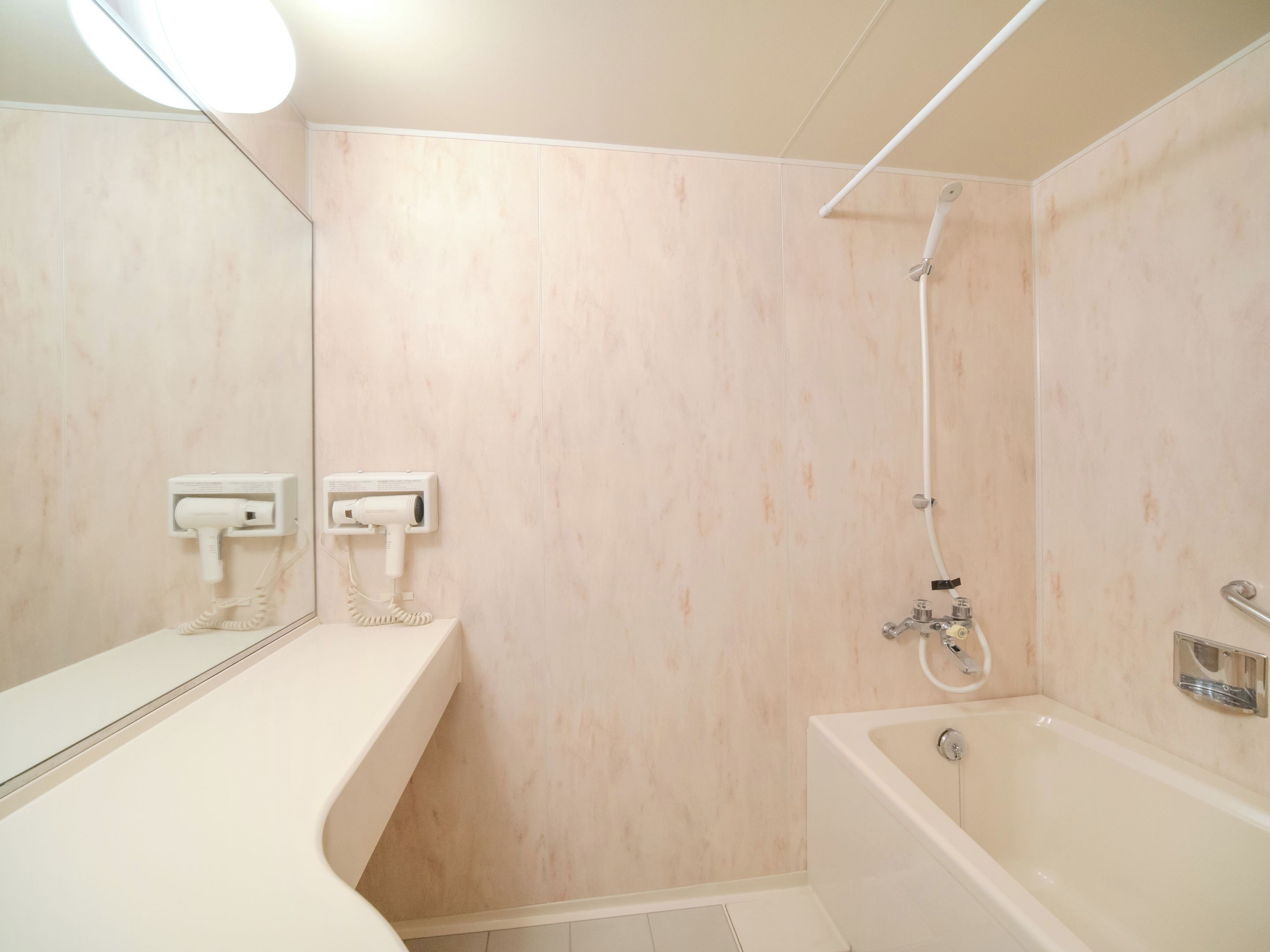 A bathroom with a bathtub, a shower, a toilet, and a mirror.