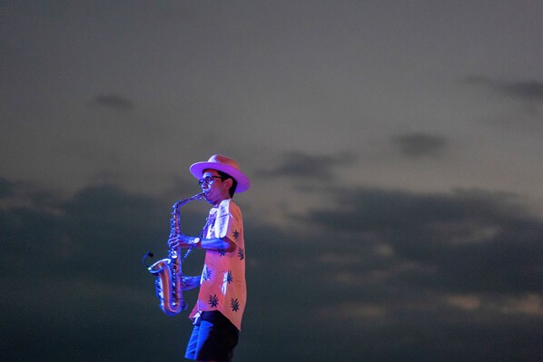Una persona tocando el saxofón sobre un escenario.