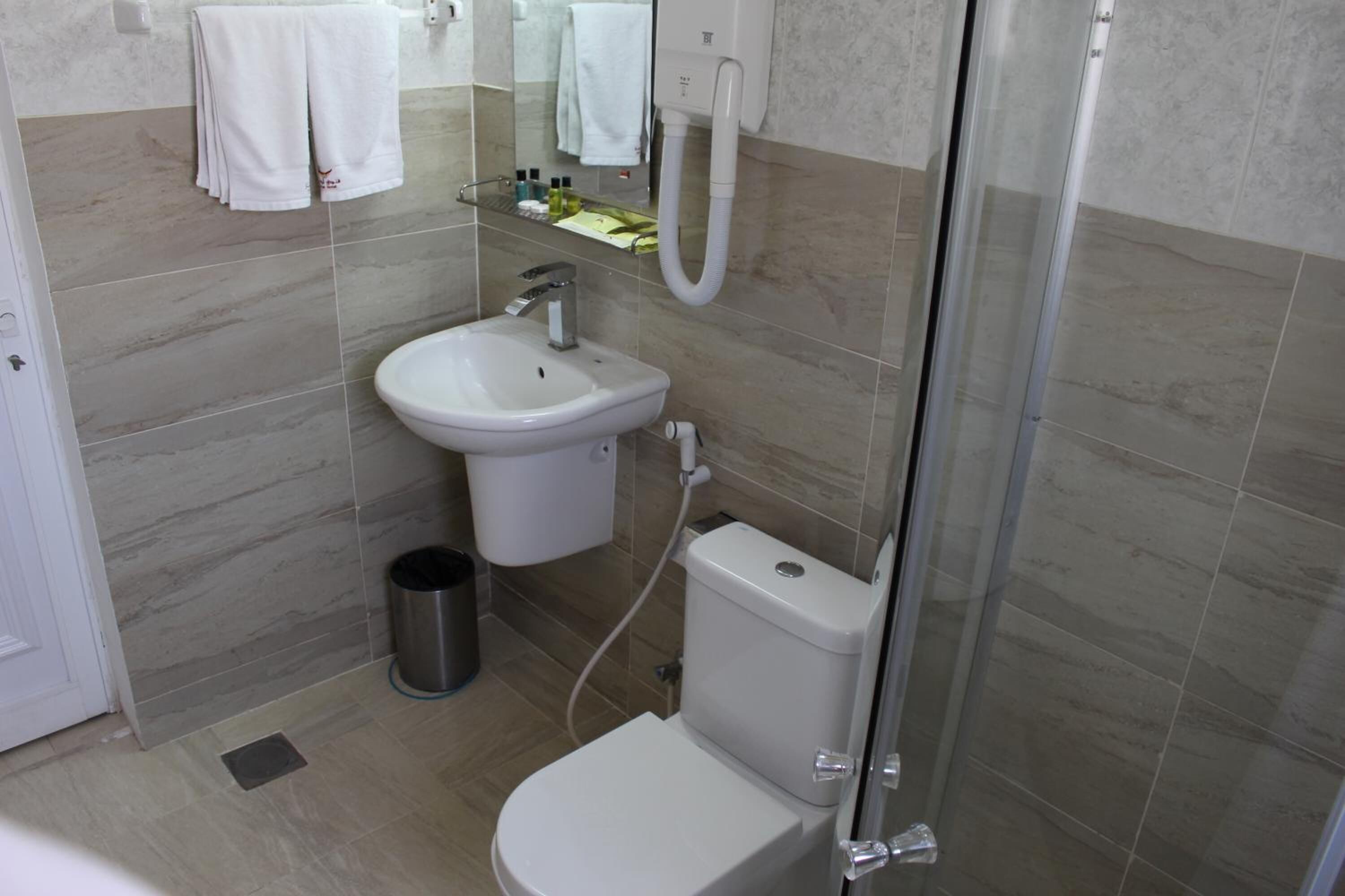 Un baño con inodoro, lavamanos y ducha.