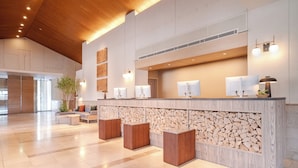 A spacious lobby with a wooden ceiling, a reception desk with a wood and stone design, and a seating area with a plant. - Wan WanParadise Tateshina (Tateshina)