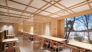 A modern interior with wooden tables and chairs, a slatted partition, and a view of a snowy landscape through large windows. - Wan WanParadise Tateshina (Tateshina)