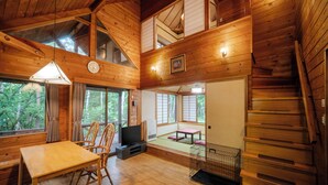 A wooden cabin with a dining area, a television, and a staircase. - Wan WanParadise Tateshina (Tateshina)
