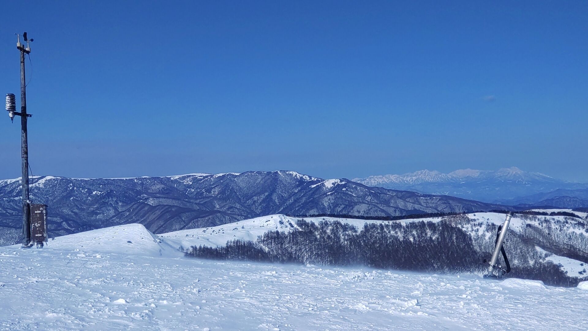 Un paysage de montagne enneigé sous un ciel dégagé.