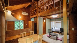 A wooden cabin interior with a dining area, a loft bedroom, and a small living space. - Wan WanParadise Tateshina (Tateshina)