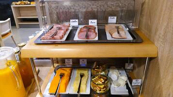 A breakfast buffet with labeled sections for ham, bacon, and poulet.