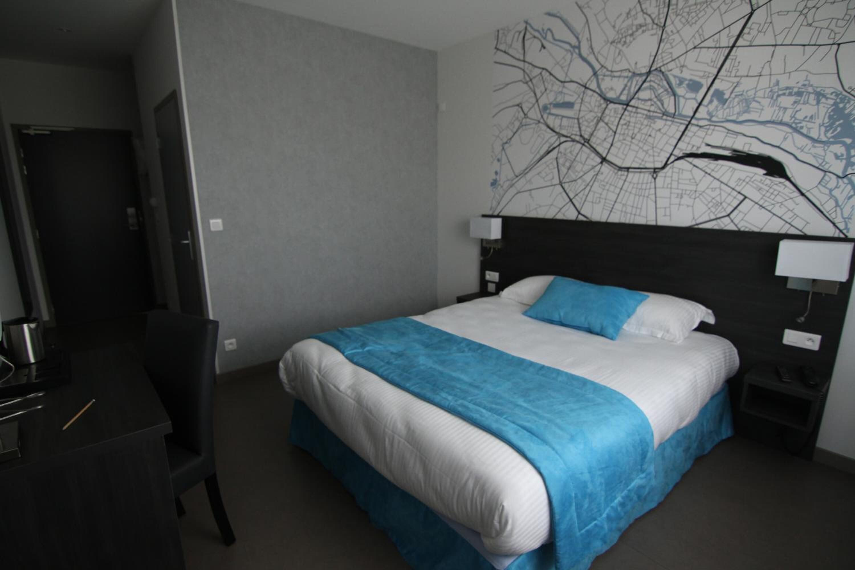 Una habitación de hotel con cama, escritorio y silla.
