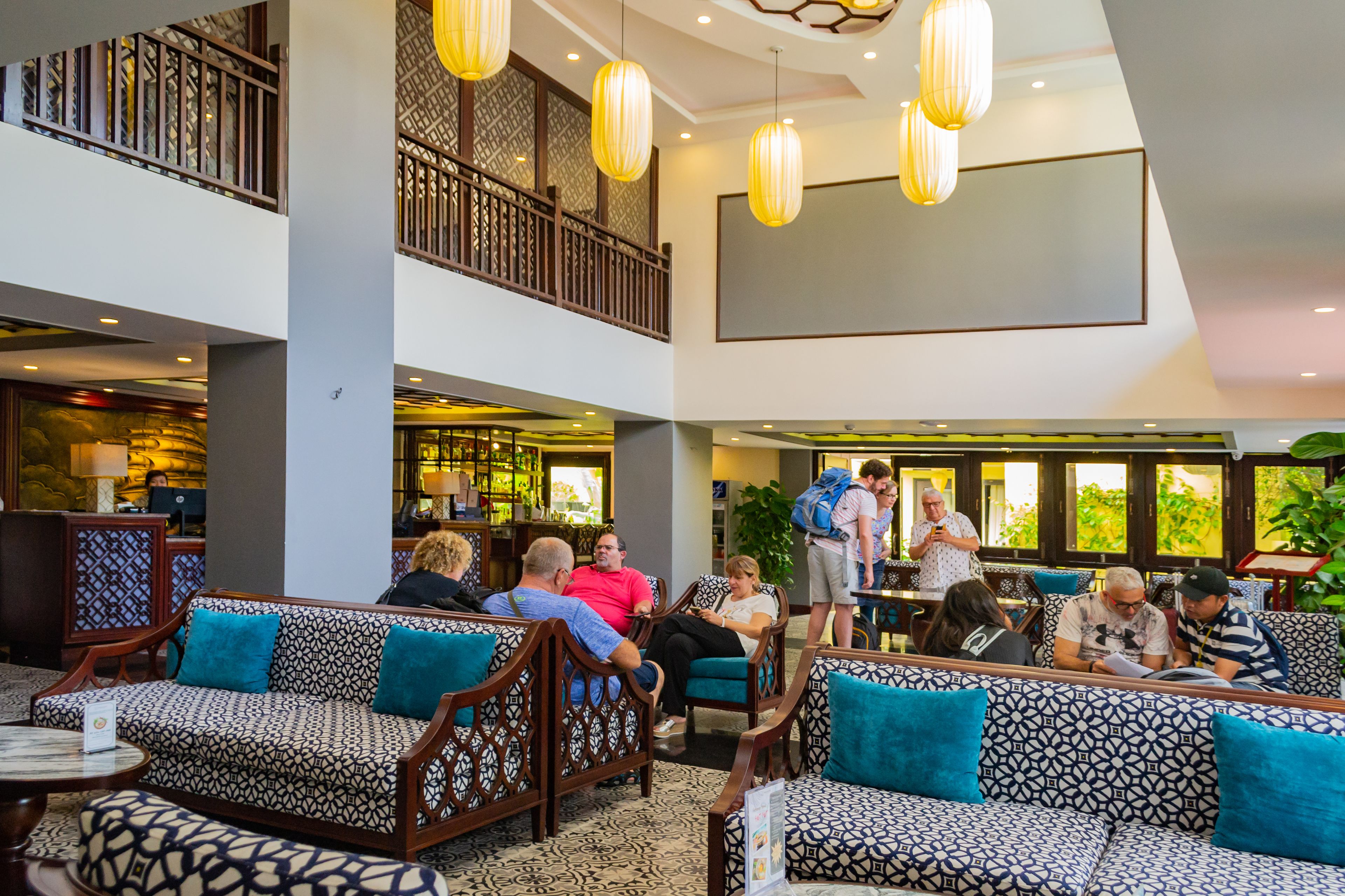 A spacious lobby with multiple seating areas, a bar, and a staircase leading to an upper level.