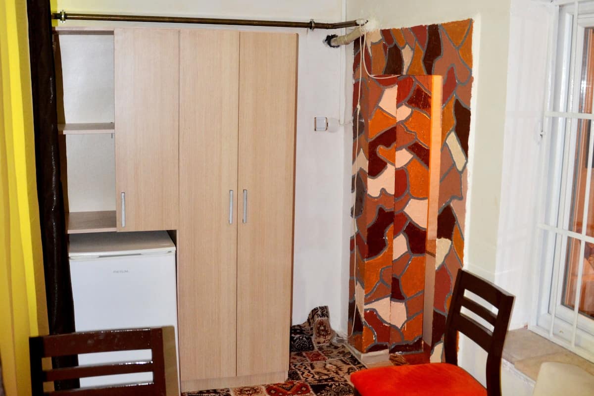 Un espacio habitable compacto con kitchenette, comedor y sofá.