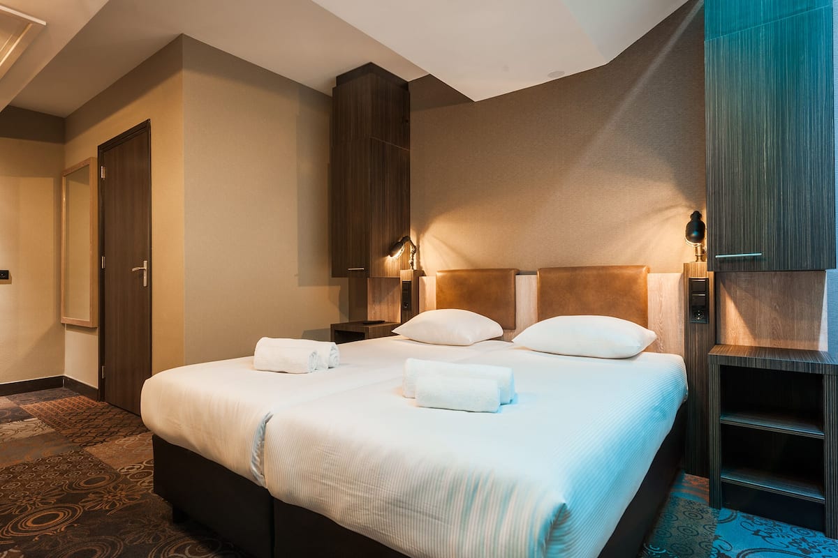 Ett hotellrum med en stor säng, två sängbord, en garderob och en liten sittgrupp.