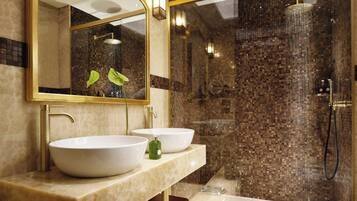 A bathroom with two large sinks, a mirror, and a shower area with mosaic tiles.