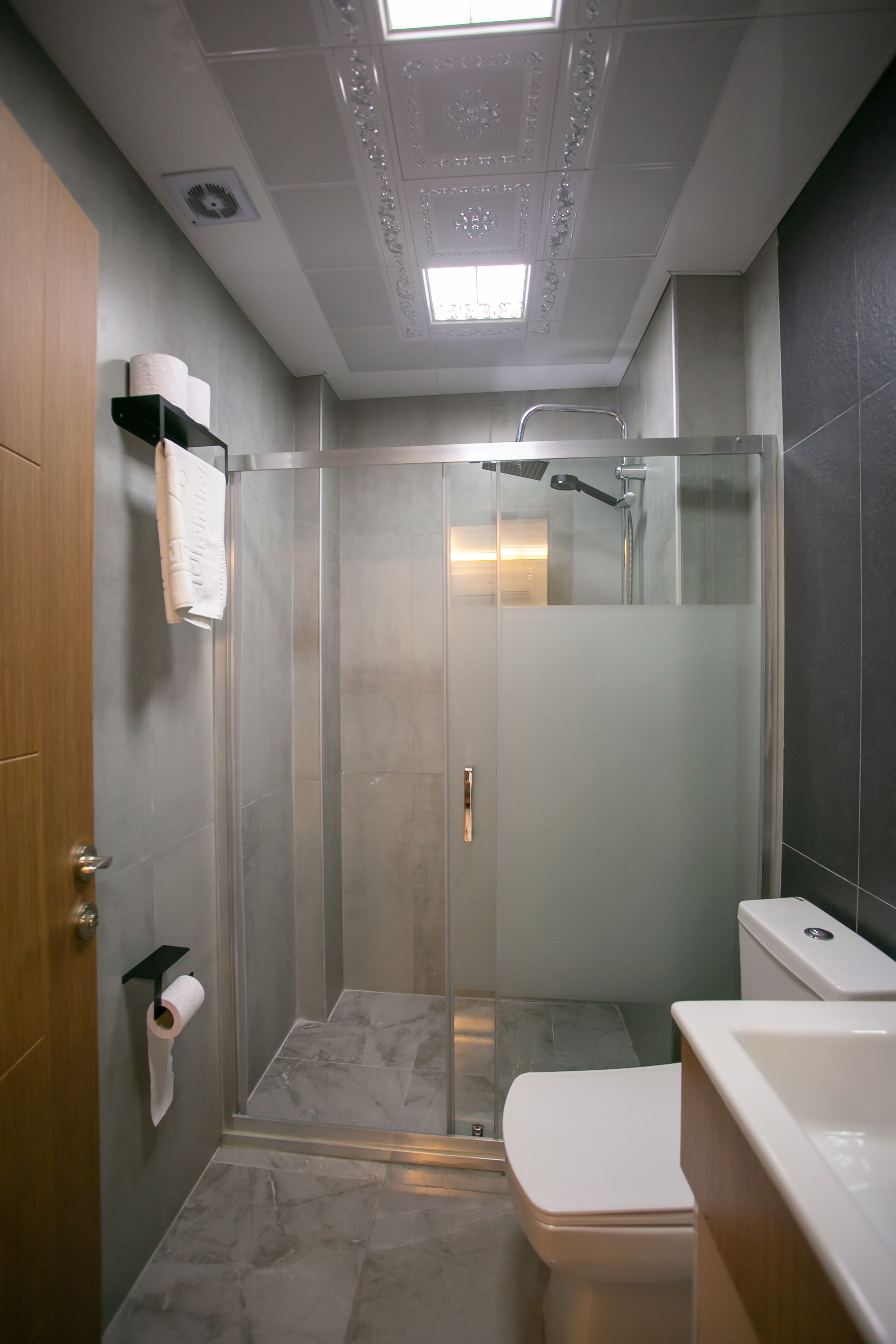 Un bagno moderno con doccia vetrata, un water e un lavandino.