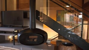 Una sala de estar moderna con chimenea, televisor y escalera.