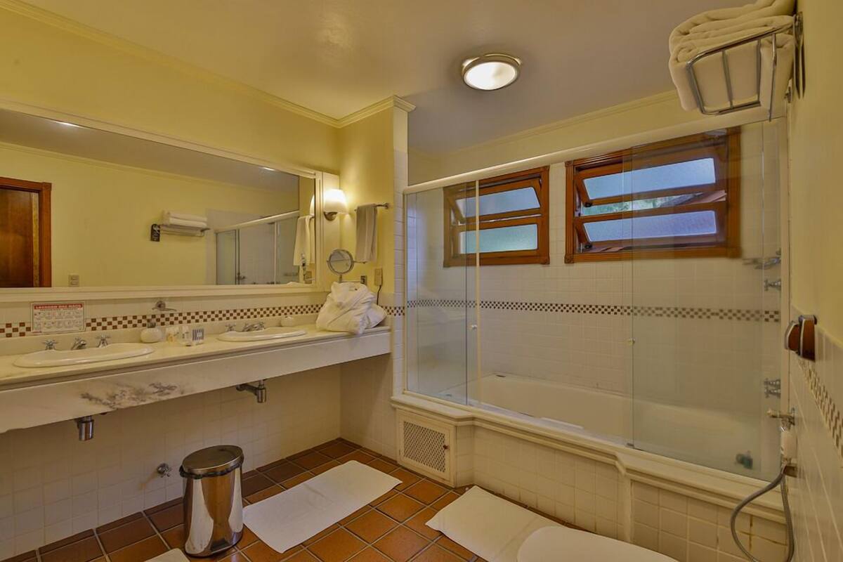 Une salle de bain avec deux lavabos, une douche et des toilettes.