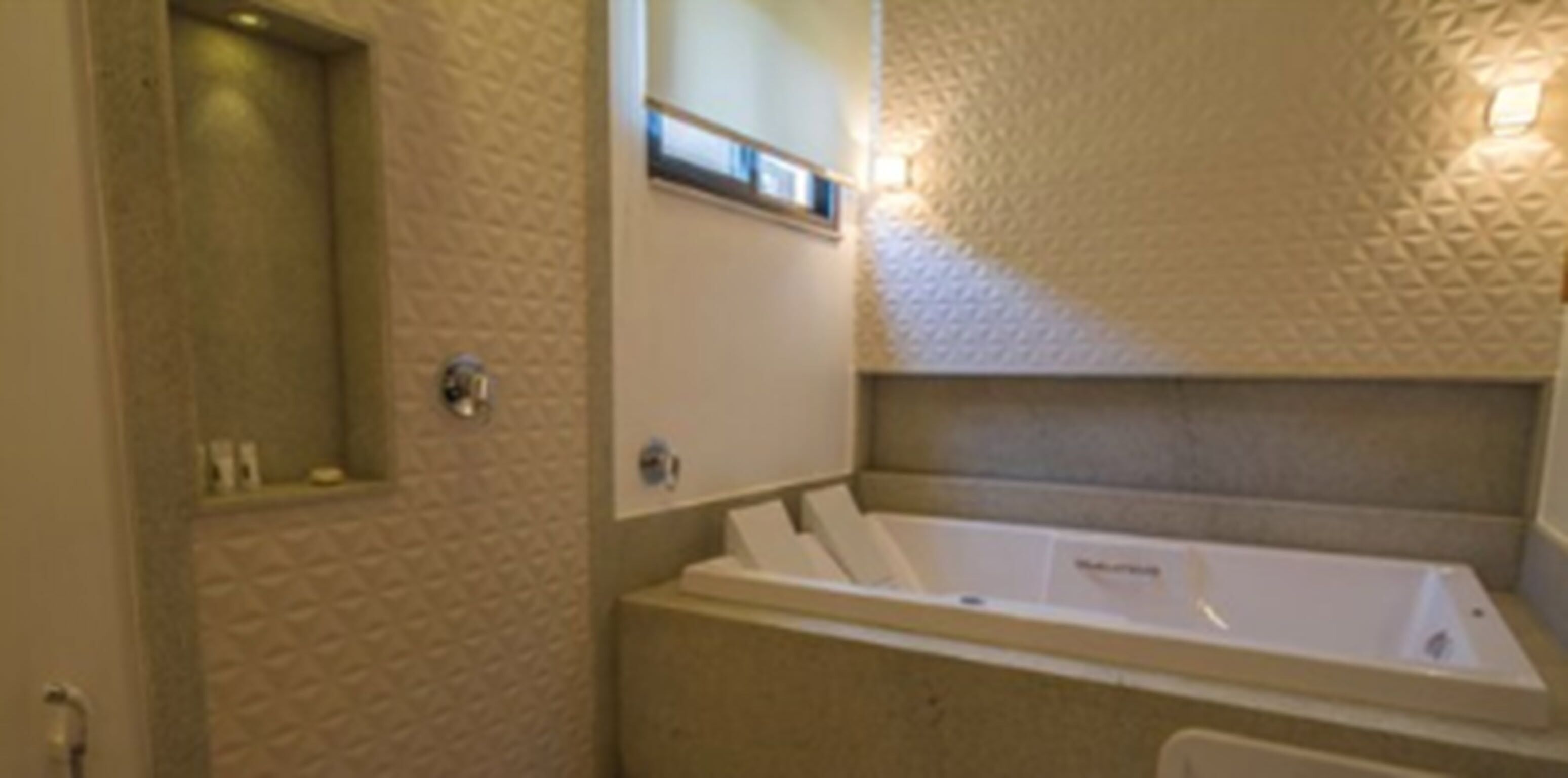 A bathroom with a bathtub, a shower, and a towel rack.