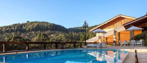 Una piscina techada, una piscina al aire libre de temporada, sombrillas