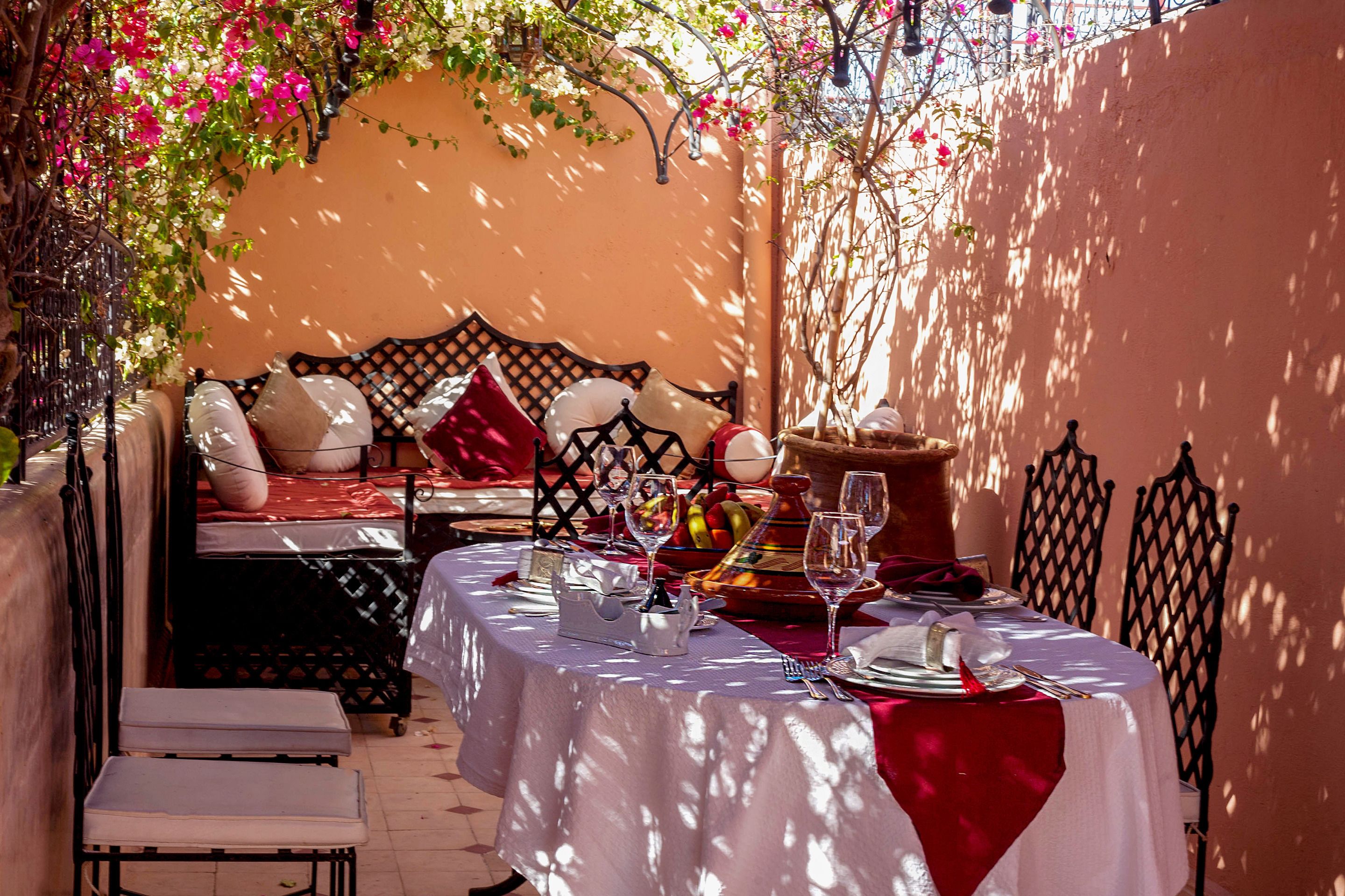 A dining area with a table set for two, featuring a white tablecloth and red napkins.