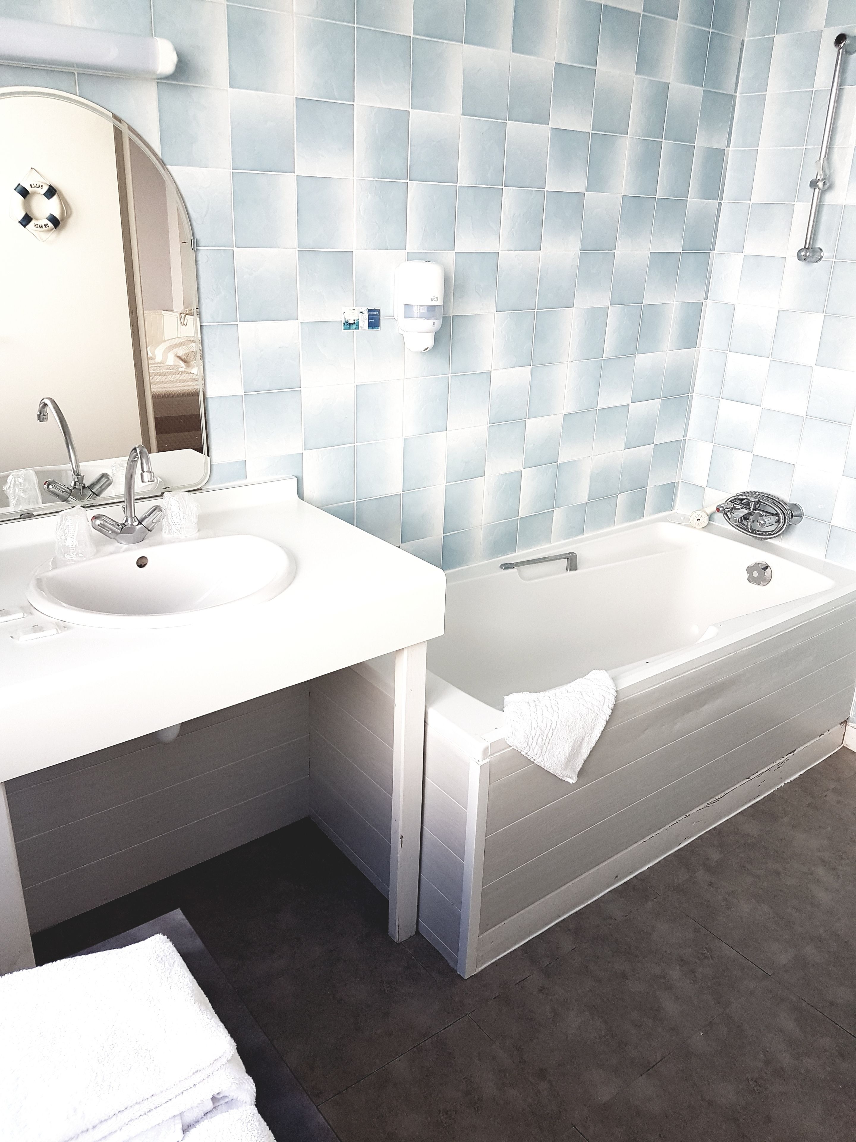 Un bagno moderno con due lavandini, una vasca da bagno ampia e uno specchio.