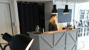 Un espacio de oficina moderno con un escritorio central, un caballito de madera y lámparas colgantes.
