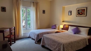 A hotel room with two beds, a desk, and a window with curtains. - Hostal The Place Miraflores (Lima)