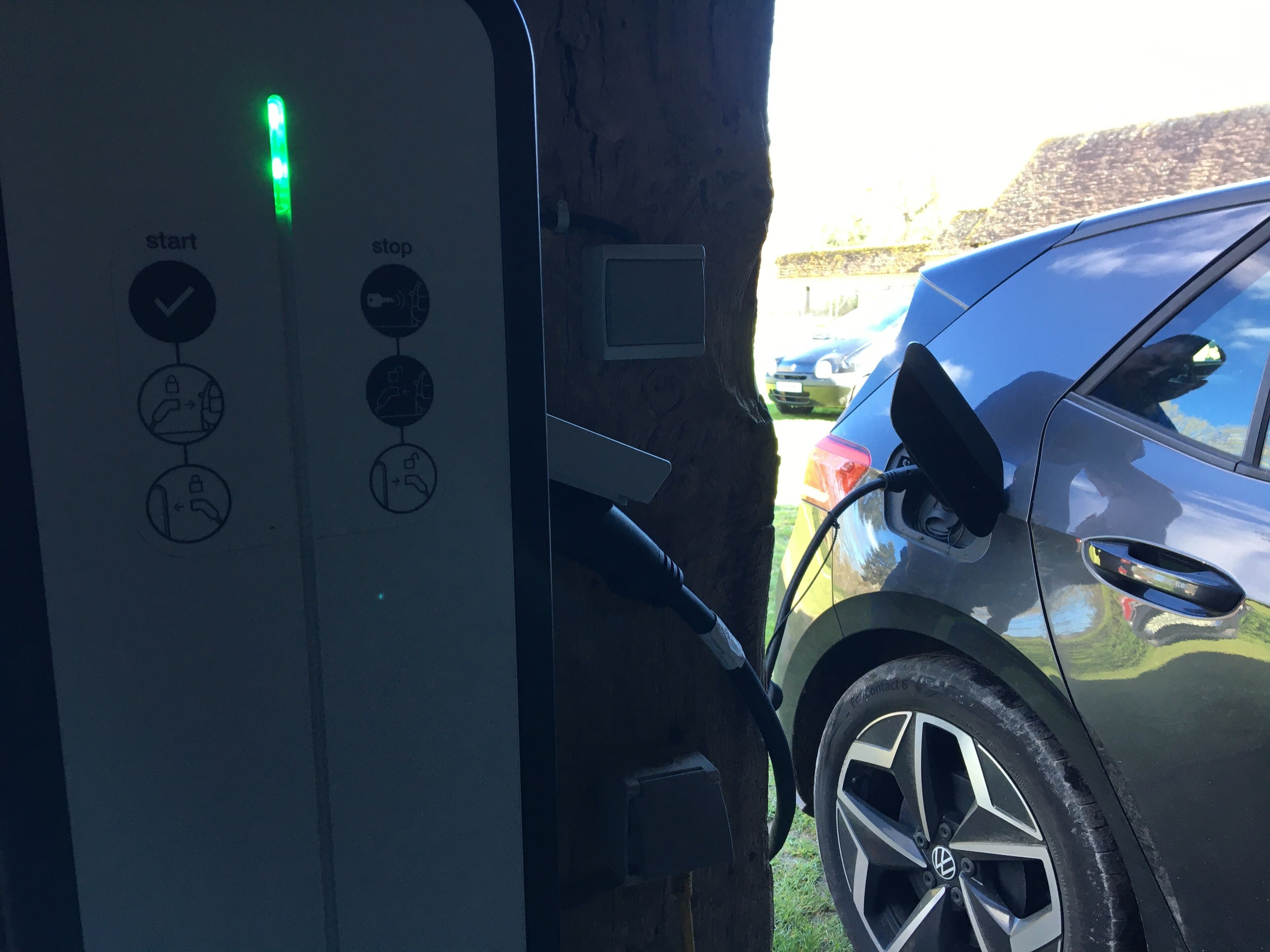 Une borne de recharge pour véhicules électriques avec une voiture branchée.