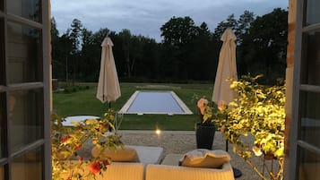 Una piscina al aire libre de temporada, sombrillas