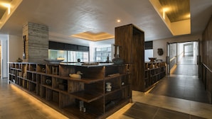 A modern kitchen with wooden shelves, a central island, and a view of the adjacent dining area. - Zaborin (Kutchan)