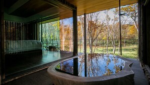 A modern interior with a large window, a seating area, and a reflective water feature. - Zaborin (Kutchan)