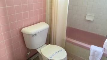 Un baño con inodoro, cortina de ducha y bañera.