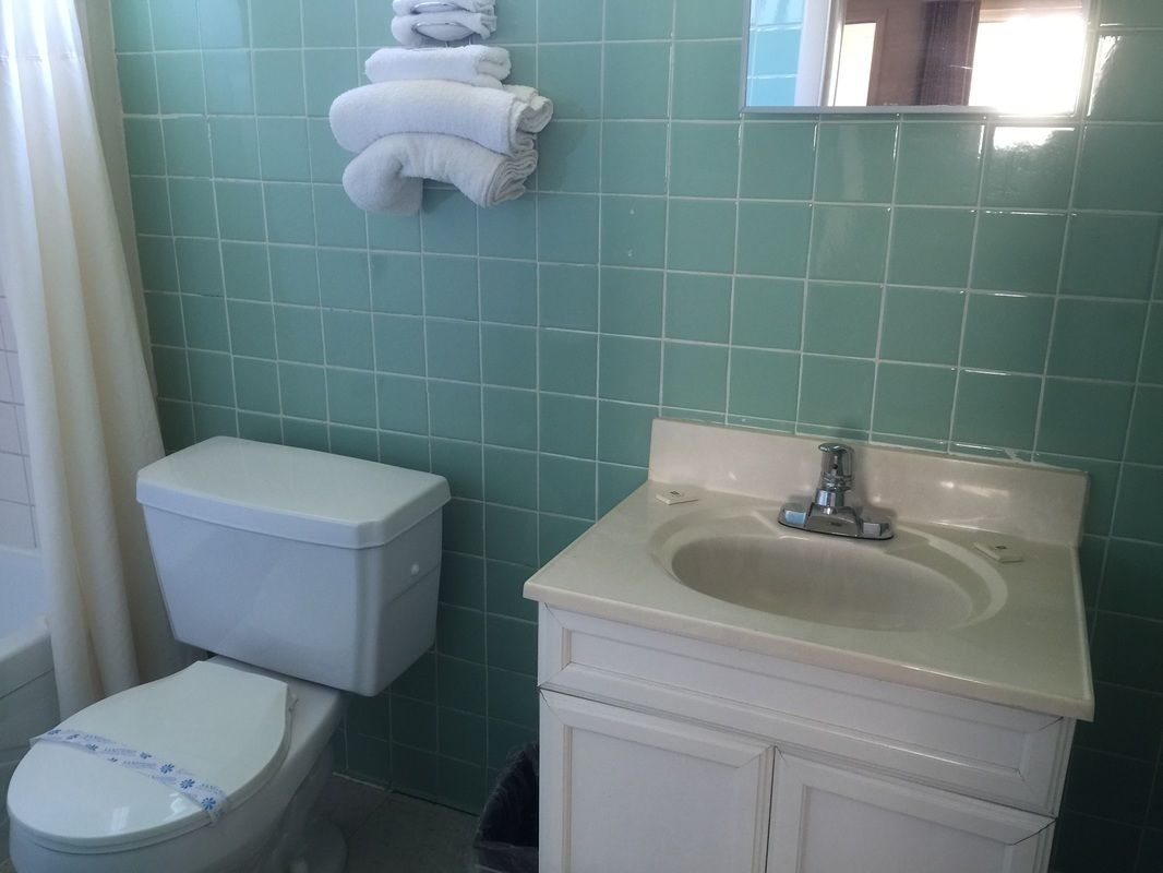 A bathroom with a toilet, sink, and a towel rack.