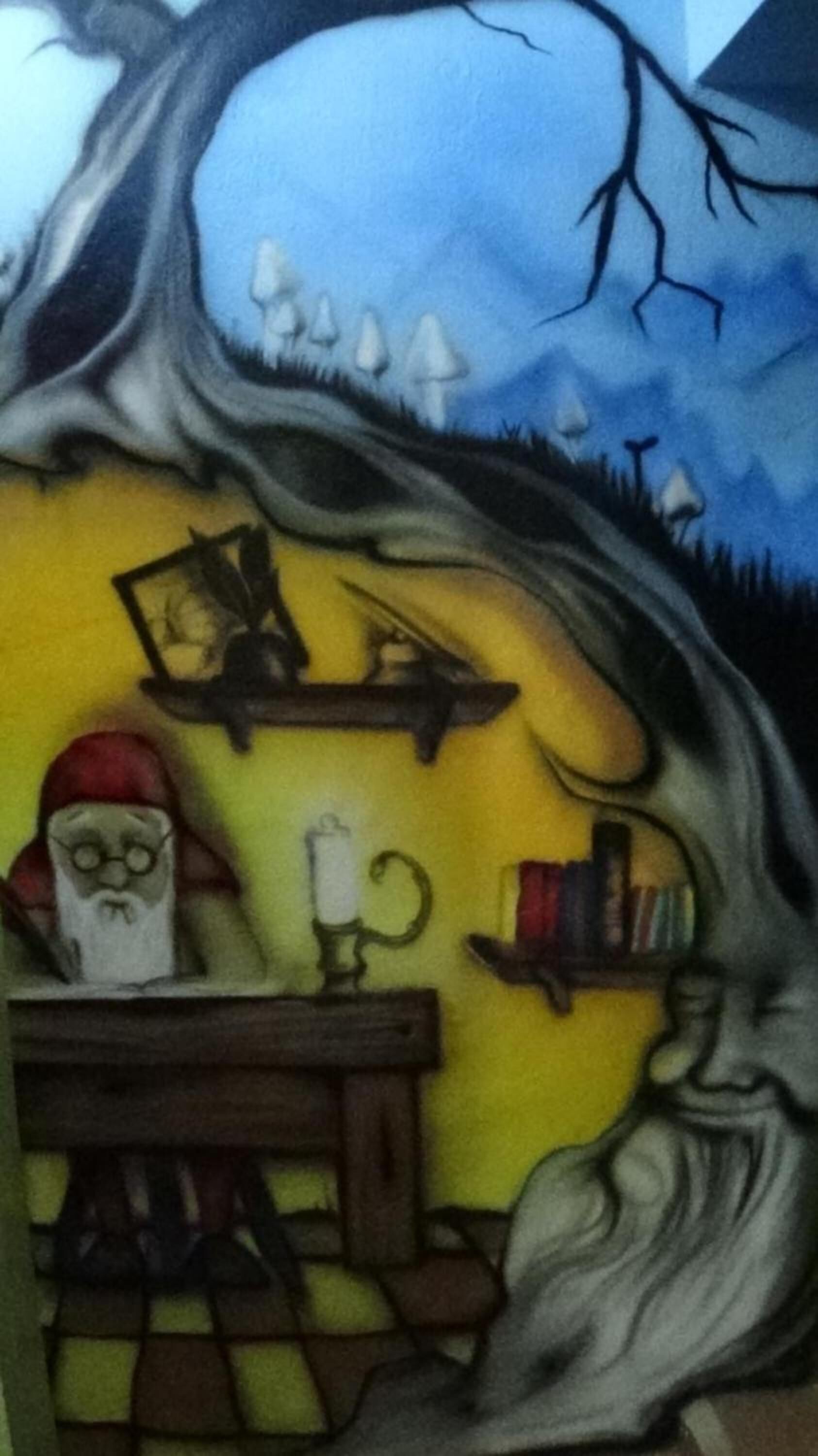 Ein Zimmer mit einem großen Baumstamm als Wand, einem Holztisch und einem Stuhl.
