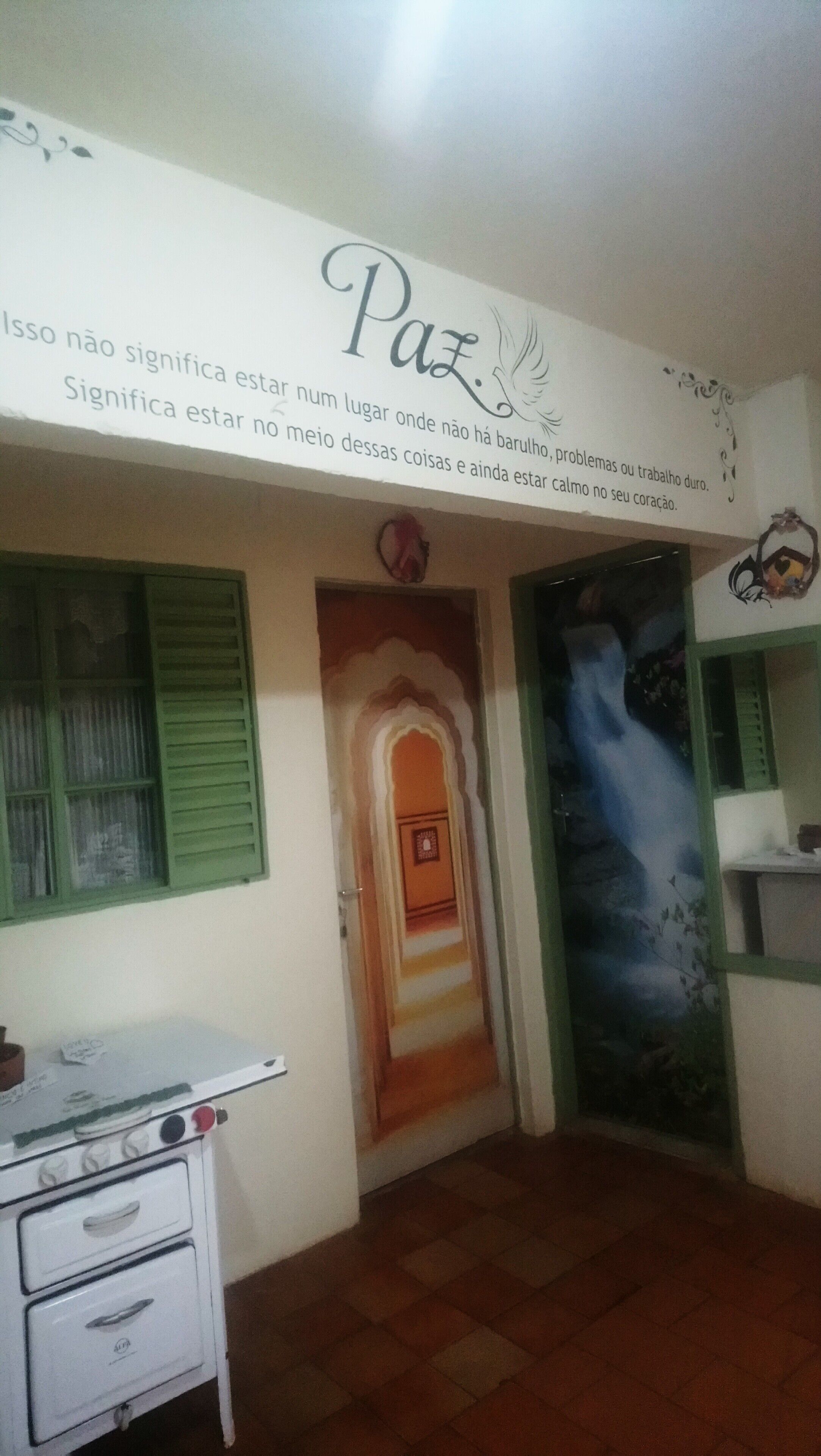 Una habitación con pared blanca, un letrero decorativo y un mural.