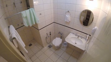Un baño con inodoro, lavabo y ducha.