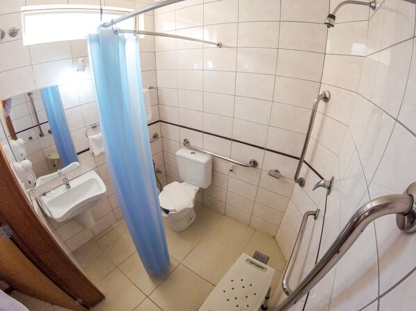 A small, tiled bathroom with a shower, toilet, and sink. - Milão Hotel (Porto Alegre)