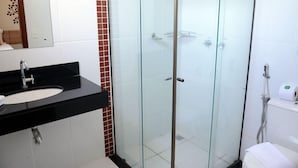 A modern bathroom with a black sink, glass shower enclosure, and white tiles. - Pousada Vitalis (Olímpia)