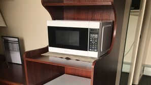 A compact kitchenette with a microwave and refrigerator.