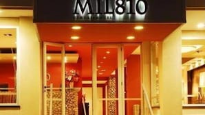 Ein Hotel Eingang mit einem Schild mit der Aufschrift 'MIL810' und einer Treppe, die zum Foyer führt.