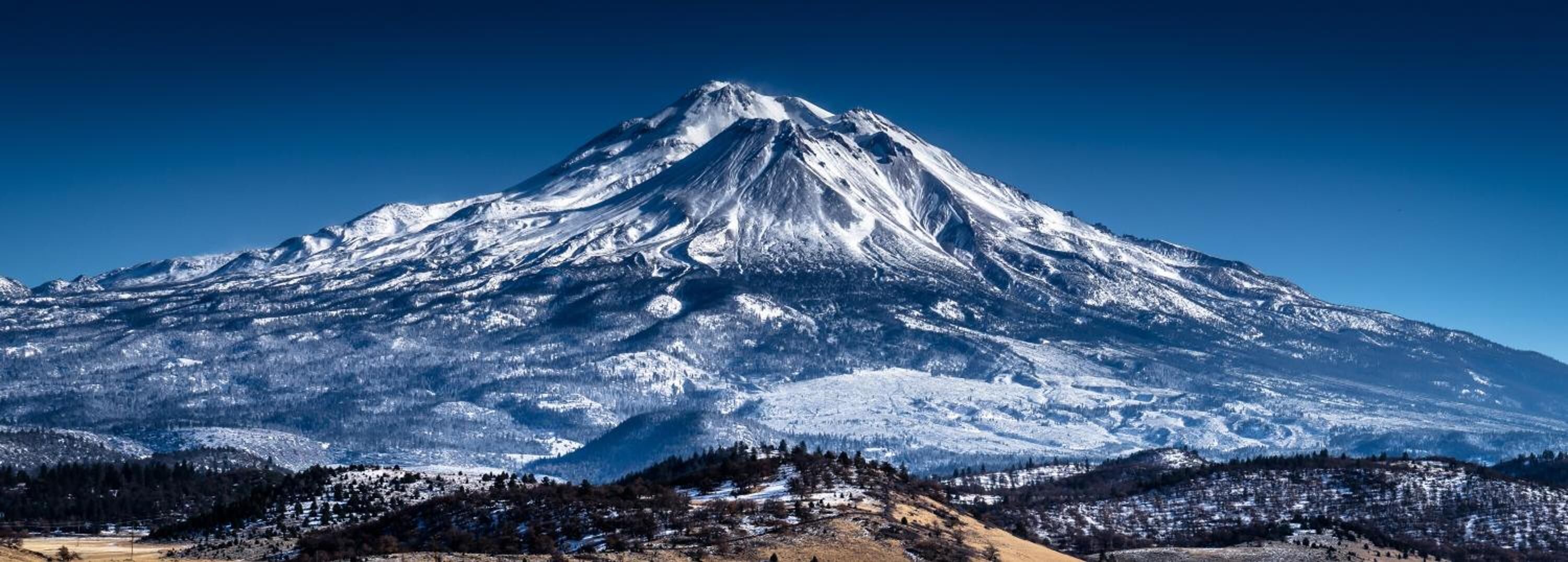 A snow-covered mountain with a clear sky.