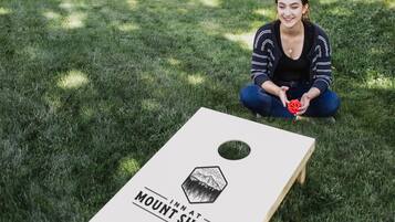 Une personne est assise sur l’herbe, devant une planche de bois sur laquelle on peut lire : « AUBERGE DU MONT SHASTA ».