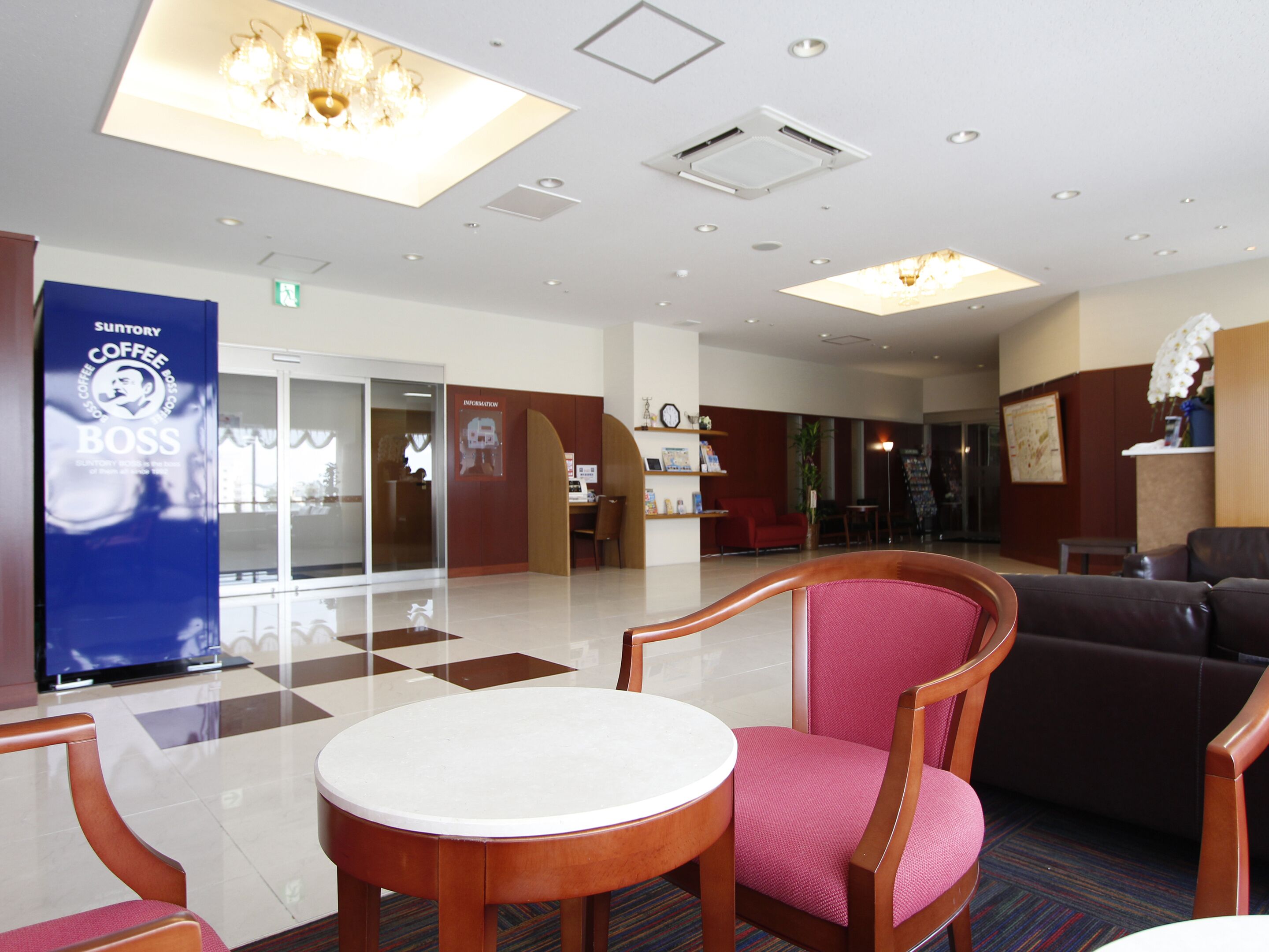 A hotel lobby with a coffee shop sign, a reception desk, and seating areas.
