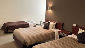 Ein Hotelzimmer mit zwei Betten, einem Nachttisch und einer Wandleuchte.